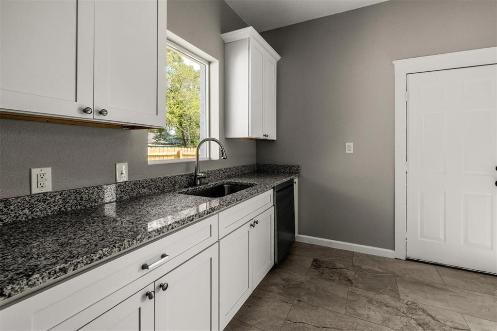 700 North Church Street Decatur, TX 76234 - Photo 6 of 15 a kitchen with granite countertop white cabinets and window