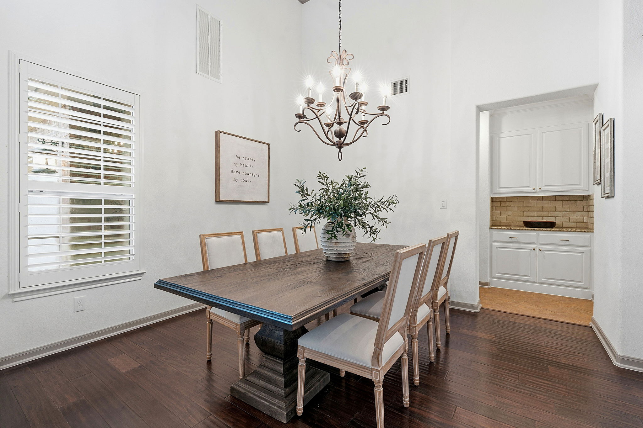 12321 Edenvale Path Austin, TX 78732 - Photo 7 of 36 Elegant dark hardwood floors and a statement chandelier define this well-appointed dining space.