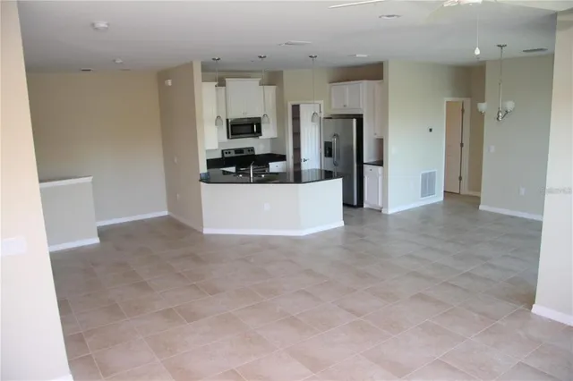 a view of a kitchen with refrigerator and a sink