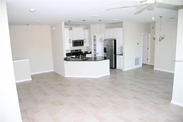 a view of a kitchen with refrigerator stove and cabinets