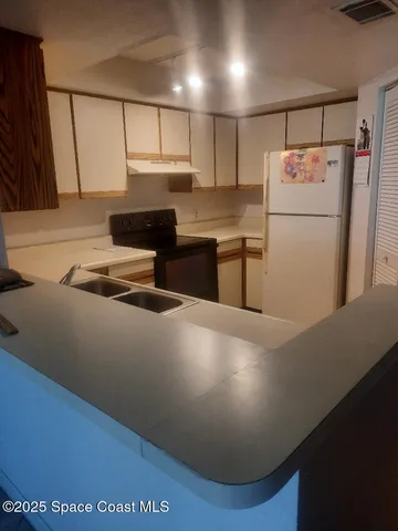 a kitchen with refrigerator and cabinets