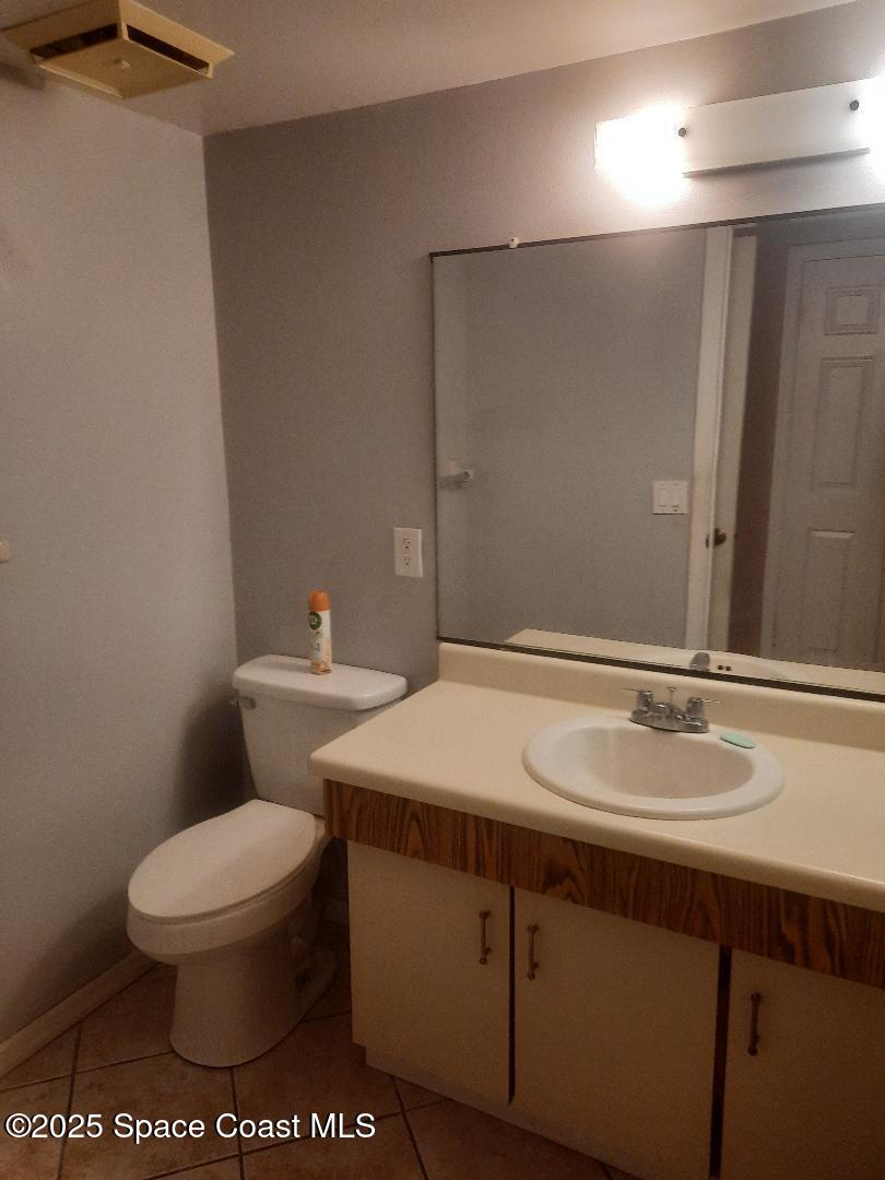 1515 Huntington Lane, Unit 928 Rockledge, FL 32955 - Photo 4 of 6 a bathroom with a sink a toilet and a mirror