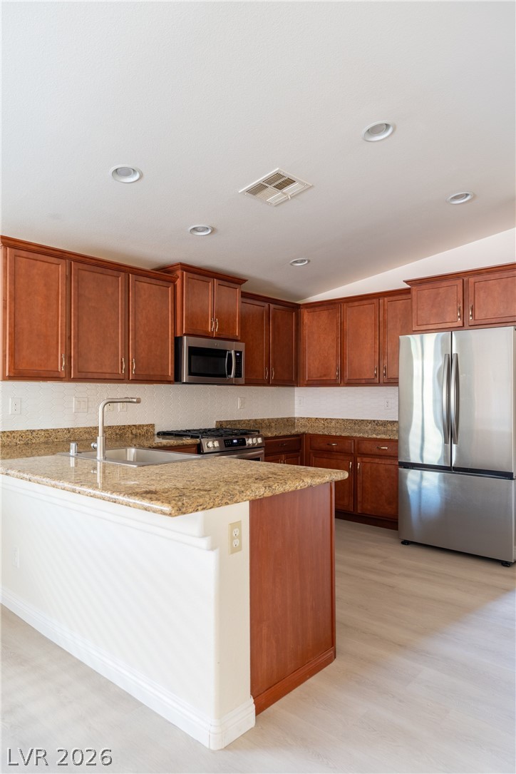 8079 Buffalo Ranch Avenue Las Vegas, NV 89147 - Photo 12 of 29 Rich wood cabinetry contrasts beautifully with granite countertops in this open kitchen layout.
