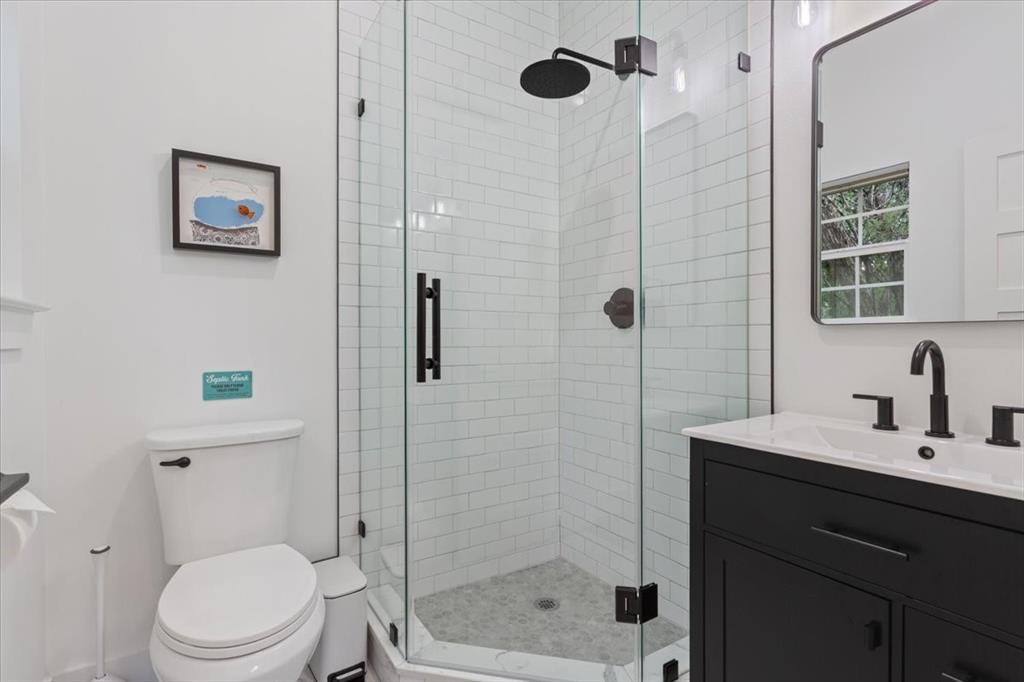15988 Wortham Bend Road China Spring, TX 76633 - Photo 32 of 40 Contemporary bathroom featuring a glass-enclosed shower with white subway tile, dark-finish shower fixtures, and a pebble-finish shower pan