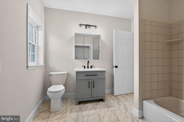 a bathroom with a sink toilet a mirror and bathtub