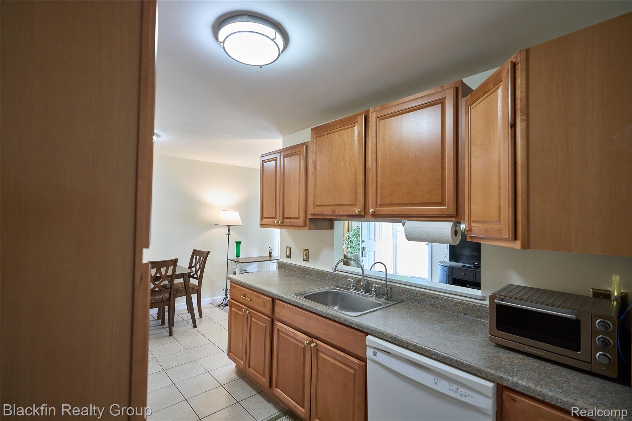 22625 Martin Road St. Clair Shores, MI 48081 - Photo 11 of 23 Kitchen with dark countertops, dishwasher, light tile patterned floors, and wood finish cabinetry