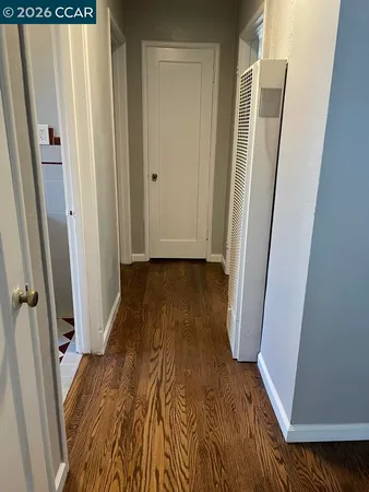 a view of a hallway with wooden floor and staircase