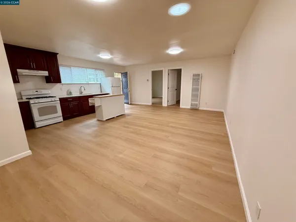 a view of a kitchen with kitchen island microwave oven a sink and dishwasher a refrigerator with wooden floor