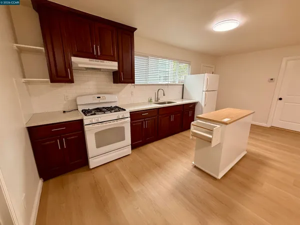 an empty room with wooden floor and entrance
