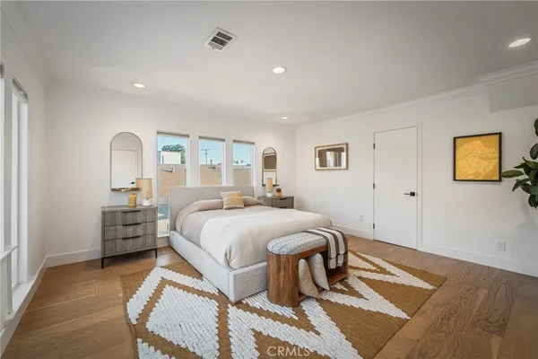 a bedroom with a bed and dresser with mirror