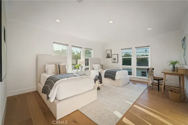 a bedroom with a bed and large windows