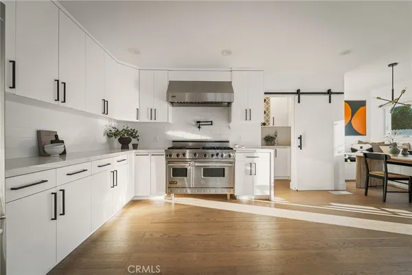 a kitchen with stainless steel appliances a refrigerator stove and white cabinets