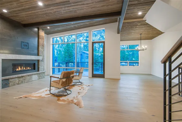 a living room with furniture a floor to ceiling window and a fireplace
