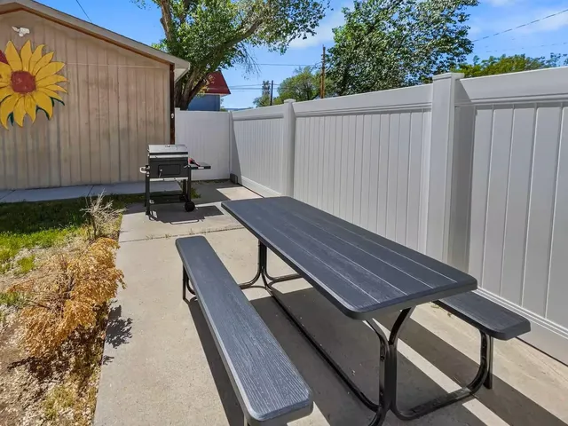 a view of a backyard with wooden floor and a iron fence