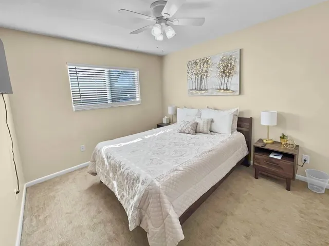 a bedroom with a bed and painting on the wall