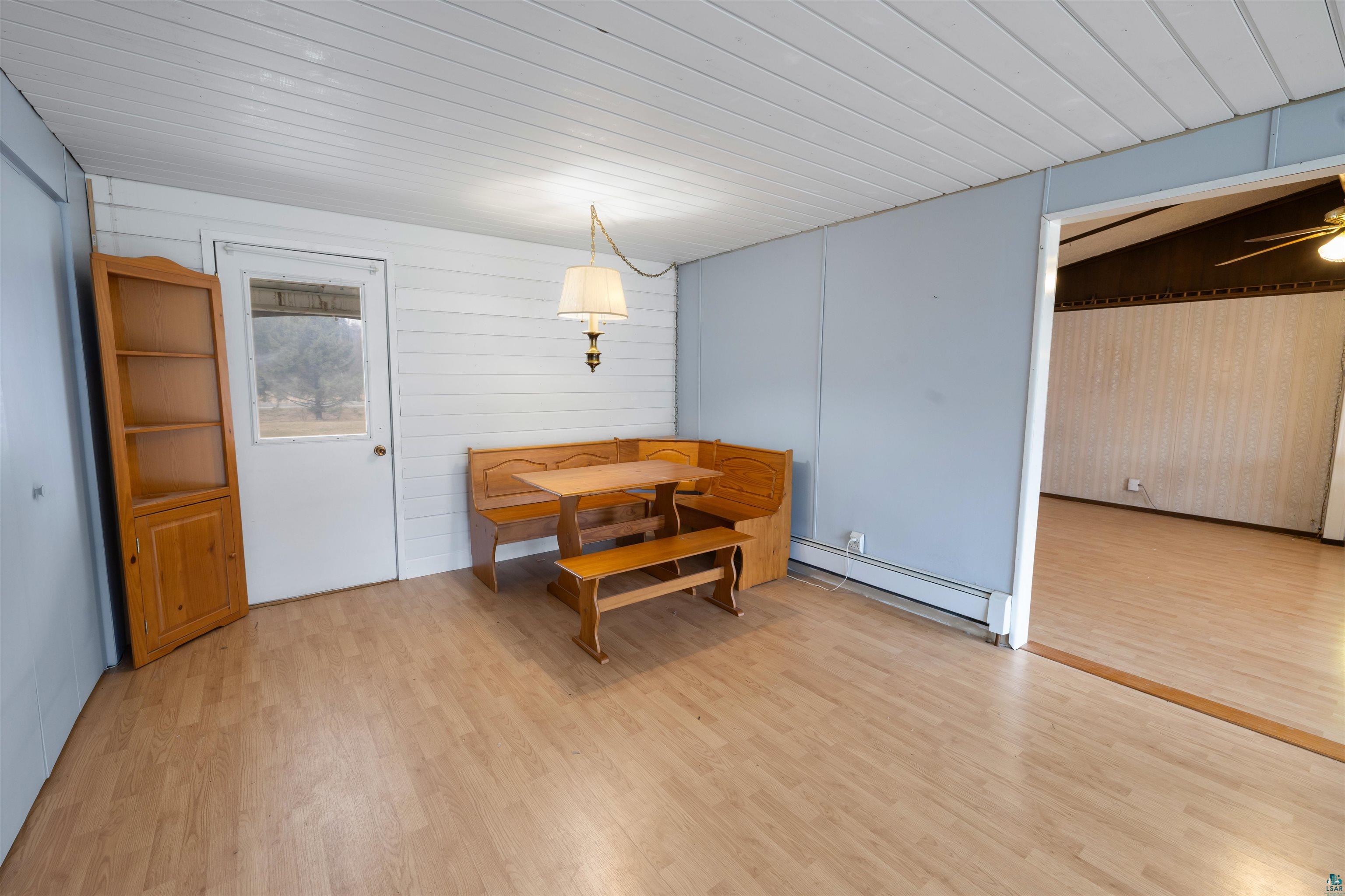 11574 Town Line Road Hibbing, MN 55746 - Photo 8 of 41 Spacious room featuring wood-finish flooring, a white paneled ceiling, and a doorway to the exterior