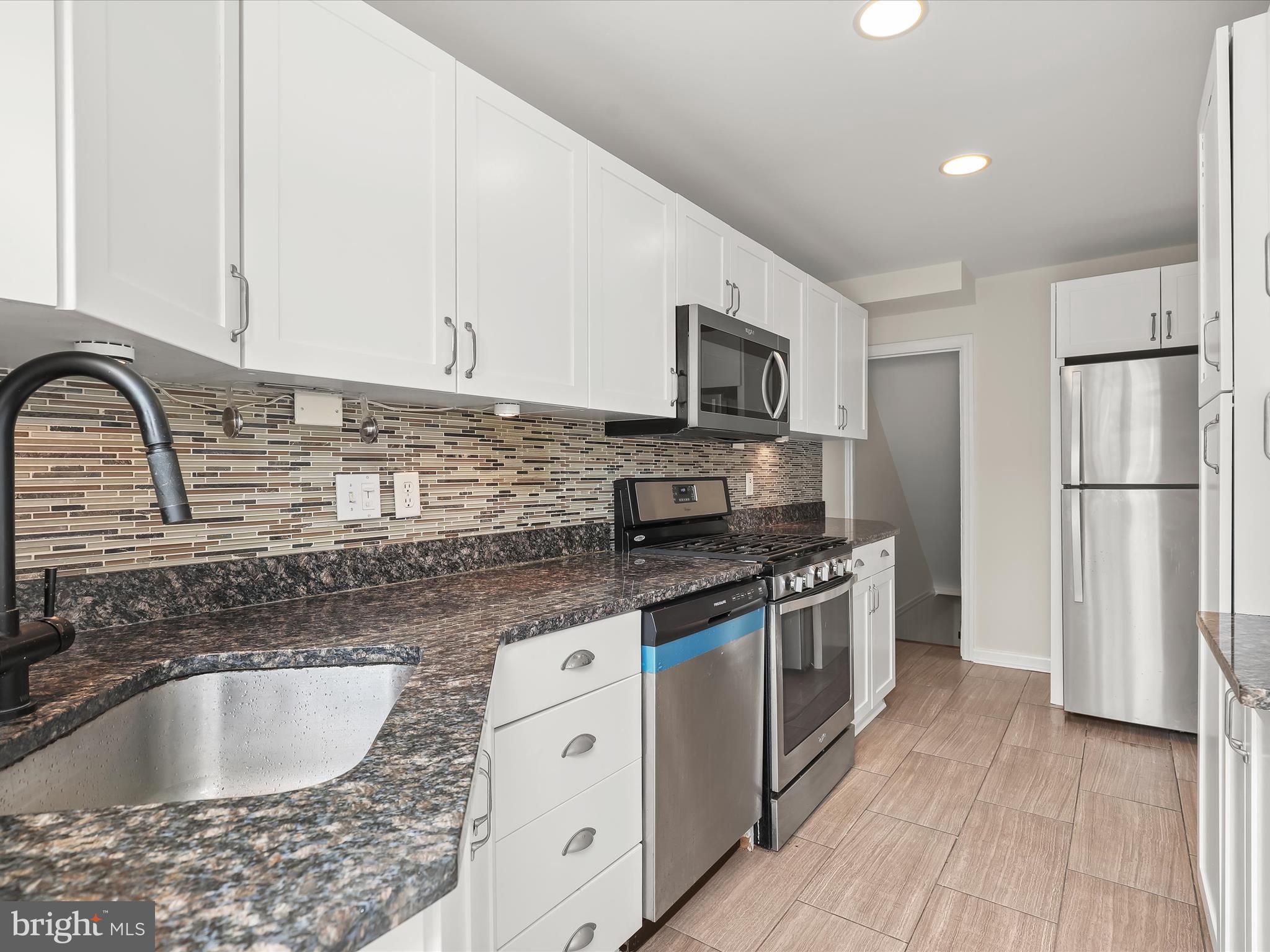 8328 Wyton Road Towson, MD 21286 - Photo 13 of 36 a kitchen with stainless steel appliances granite countertop a sink stove and refrigerator