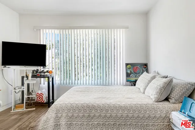 a bedroom with a bed and a flat screen tv