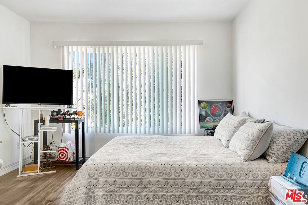1740 Hauser Boulevard, Unit 8 Los Angeles, CA 90019 - Photo 7 of 10 a bedroom with a bed and a flat screen tv