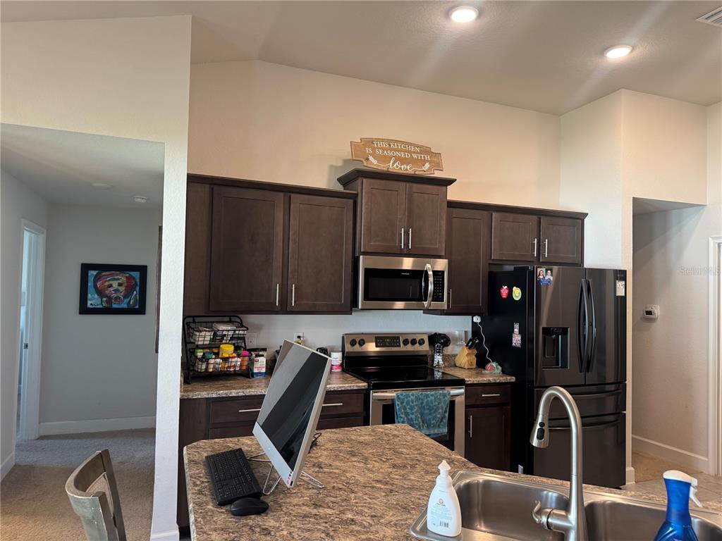 5123 Southwest 91st Street Ocala, FL 34476 - Photo 11 of 29 a kitchen with granite countertop a refrigerator and a stove top oven