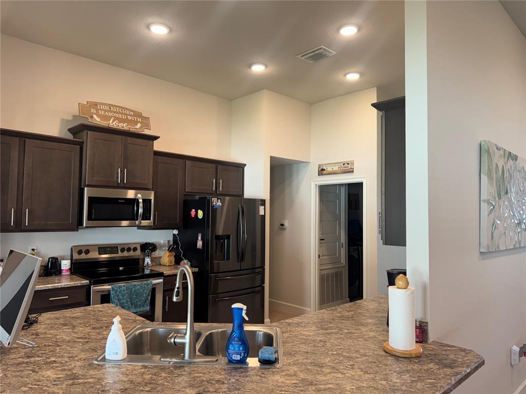 5123 Southwest 91st Street Ocala, FL 34476 - Photo 12 of 29 a kitchen with stainless steel appliances kitchen island granite countertop a refrigerator and a stove top oven