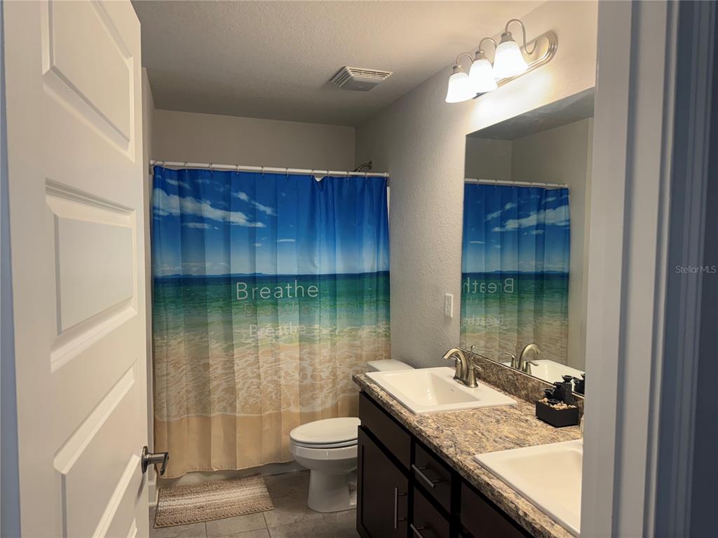 5123 Southwest 91st Street Ocala, FL 34476 - Photo 21 of 29 a bathroom with a granite countertop sink a toilet and tub