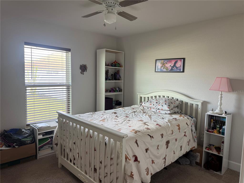 5123 Southwest 91st Street Ocala, FL 34476 - Photo 22 of 29 a bedroom with a bed and a chandelier