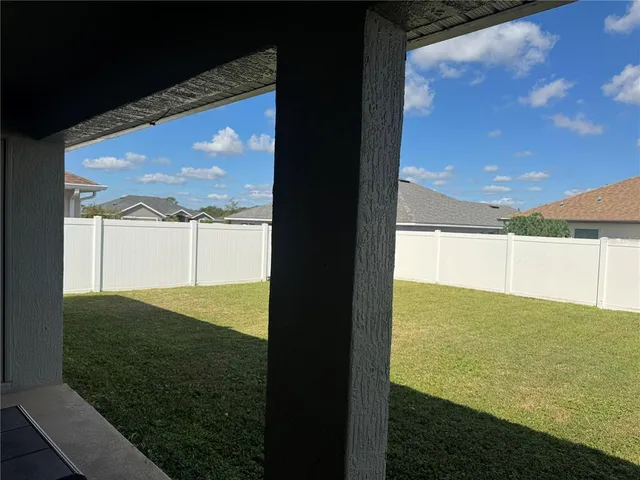 a backyard of a house with table and chairs