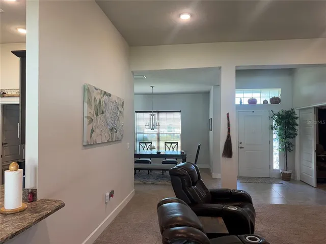 a living room with furniture and a large mirror next to a window