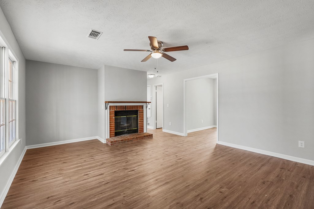 19110 Ga Highway Shiloh, GA 31826 - Photo 3 of 15 an empty room with windows a fireplace and a ceiling fan