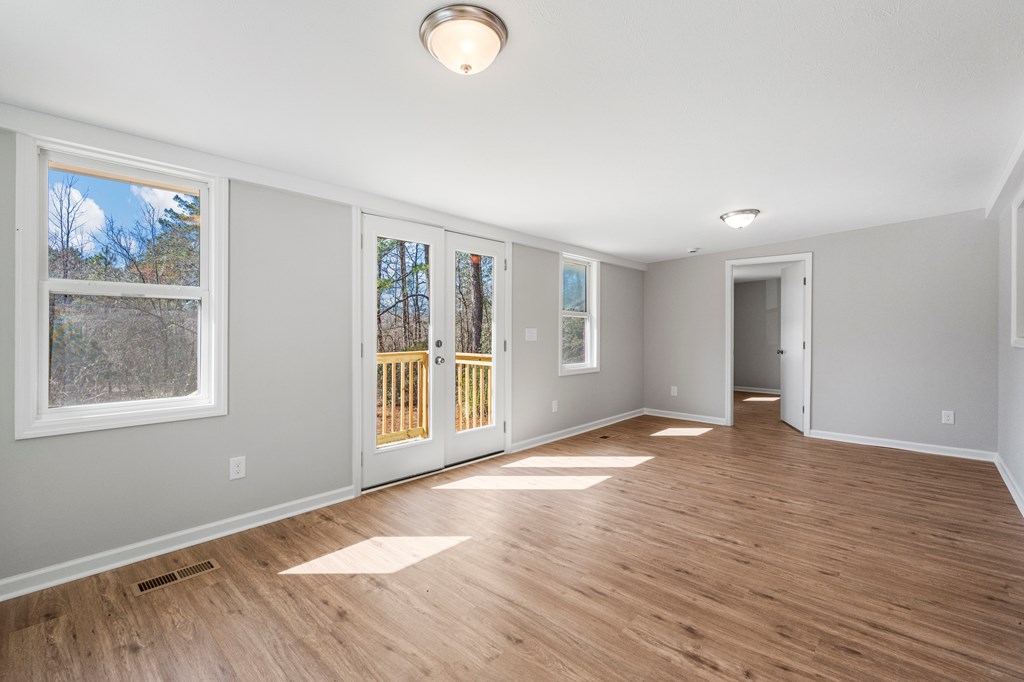 19110 Ga Highway Shiloh, GA 31826 - Photo 4 of 15 a view of an empty room with a window and wooden floor