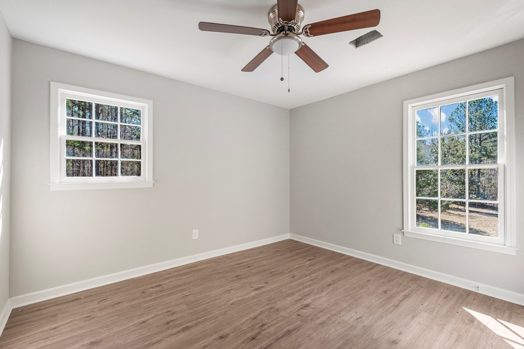 19110 Ga Highway Shiloh, GA 31826 - Photo 9 of 15 an empty room with wooden floor windows and fan