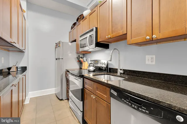 a kitchen with stainless steel appliances granite countertop a sink and a stove