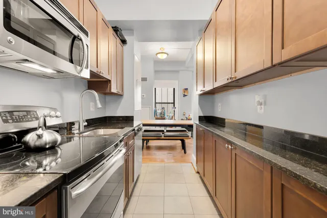 a kitchen with stainless steel appliances granite countertop a sink stove and microwave