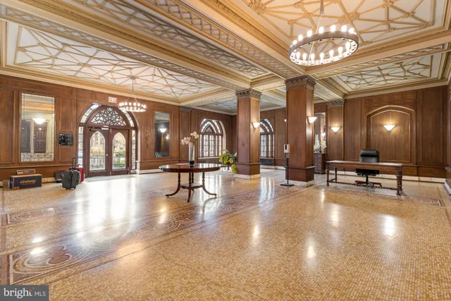 a view of a dining room with furniture a chandelier and wooden floor