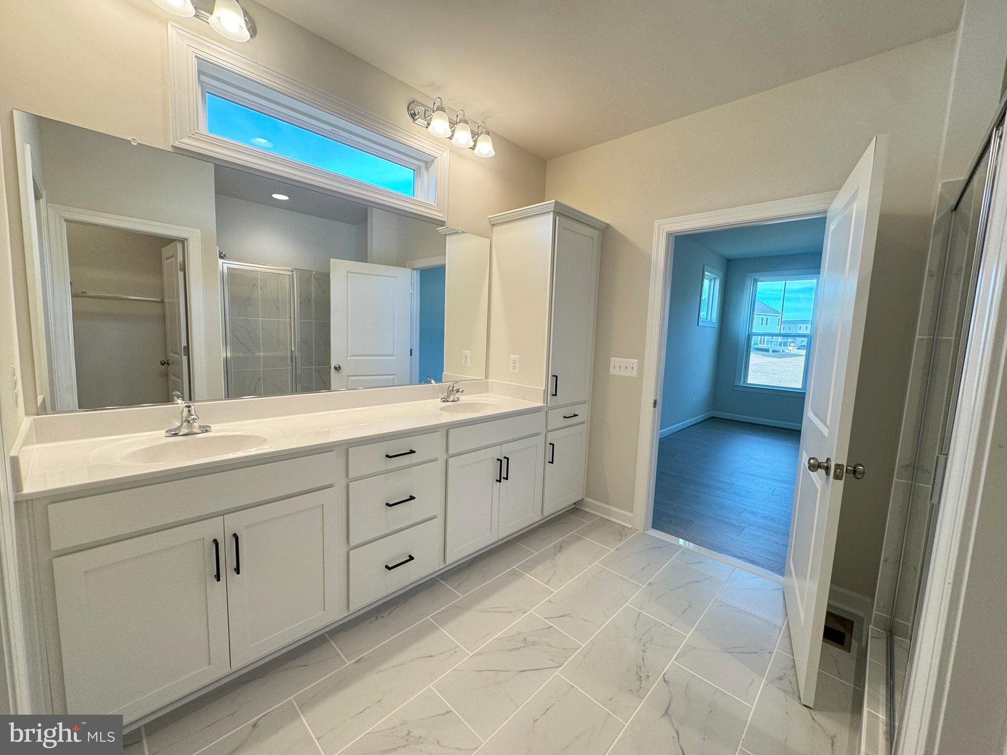 115 Sapphire Street Stephenson, VA 22656 - Photo 23 of 36 a spacious bathroom with a double vanity sink a large mirror and a shower