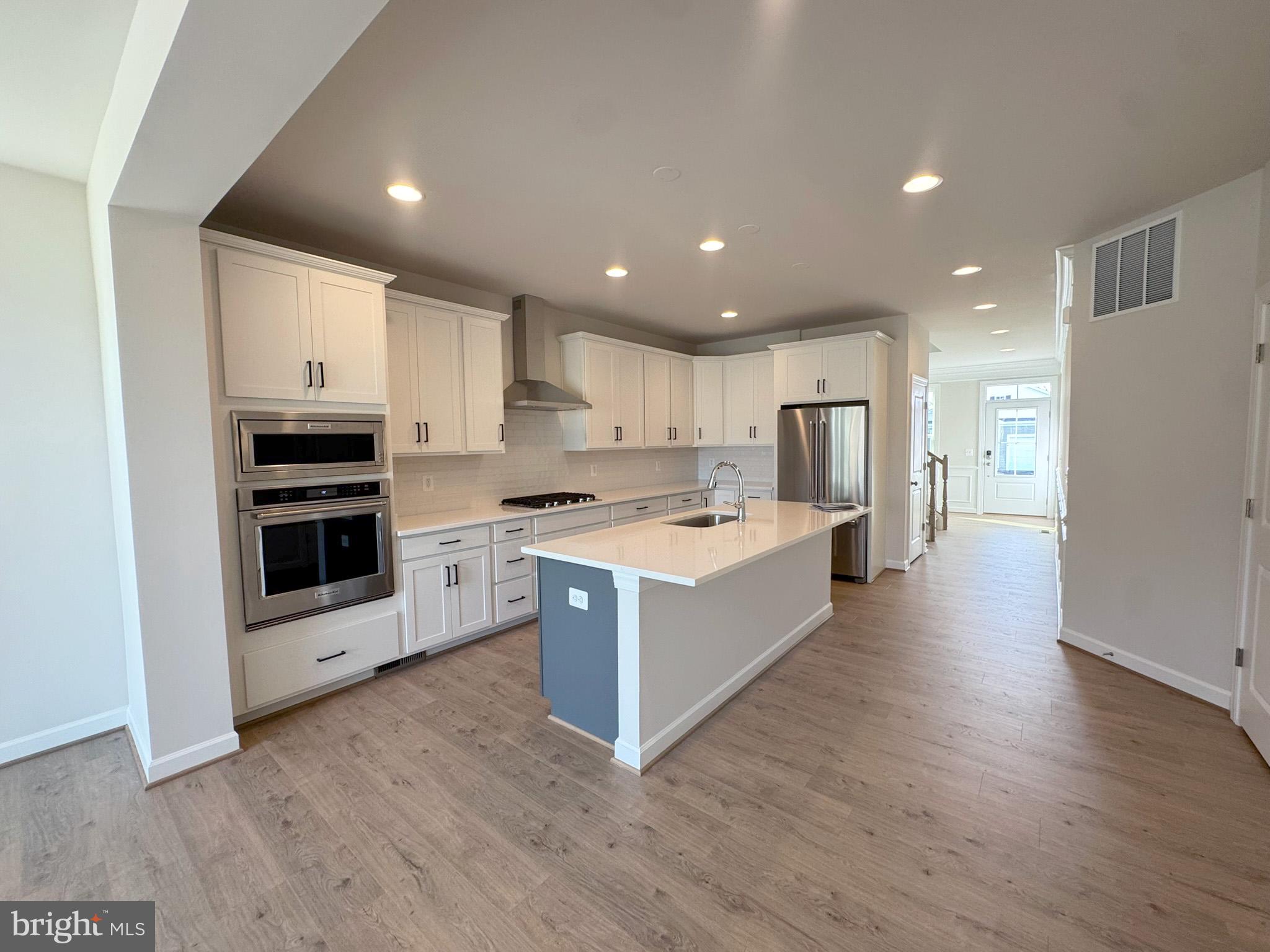 115 Sapphire Street Stephenson, VA 22656 - Photo 9 of 36 a large kitchen with stainless steel appliances granite countertop a large counter top and a stove top oven