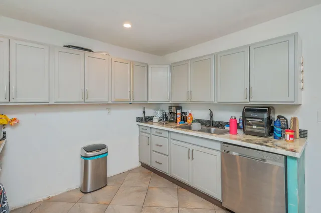 a kitchen with white cabinets and white appliances