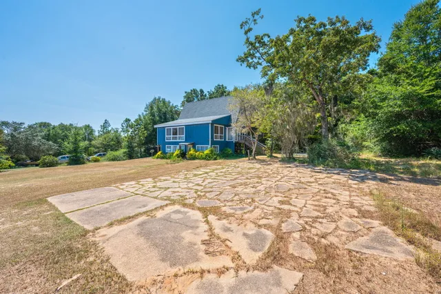 a front view of a house with a yard and trees