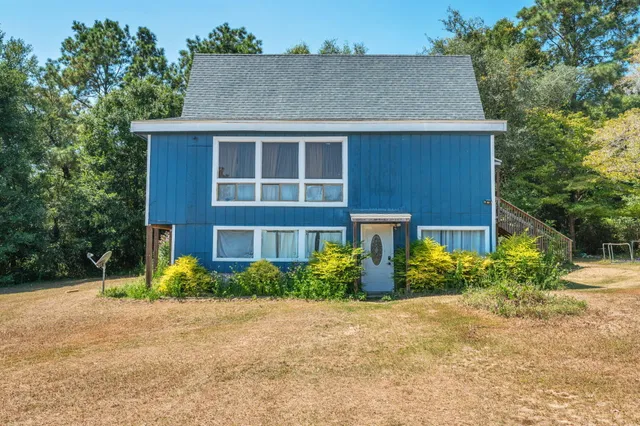 a front view of house with yard and trees around