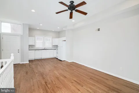 a kitchen with a sink white cabinets and white appliances