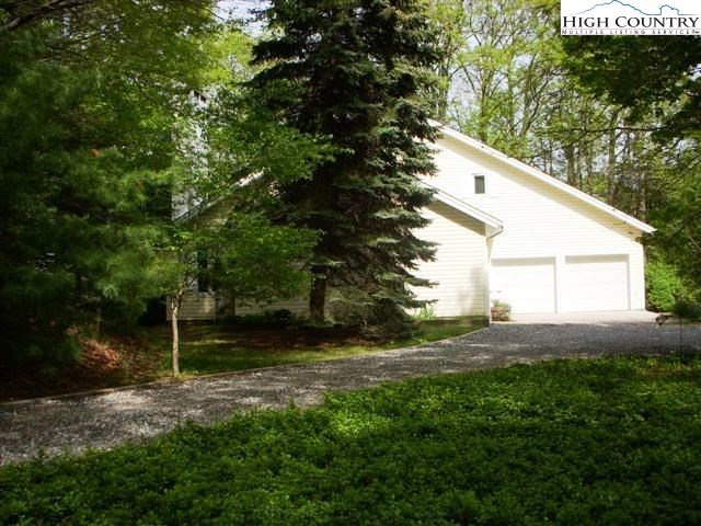 1292 Ben Miller Road Deep Gap, NC 28618 - Photo 31 of 31 a backyard of a house with plants and large trees