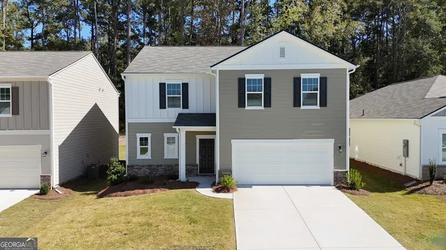 a view of a white house with large windows and large tree