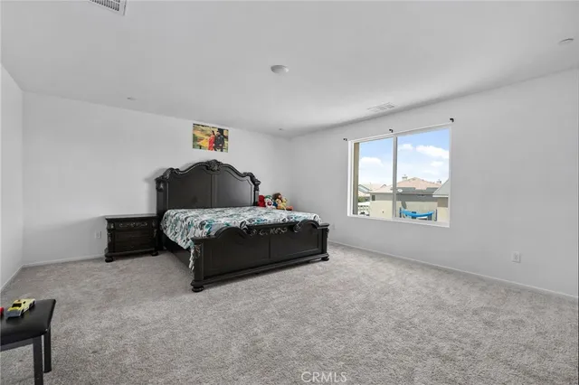 a spacious bedroom with a bed and a window