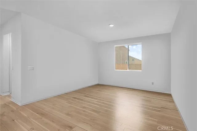 an empty room with wooden floor and a window