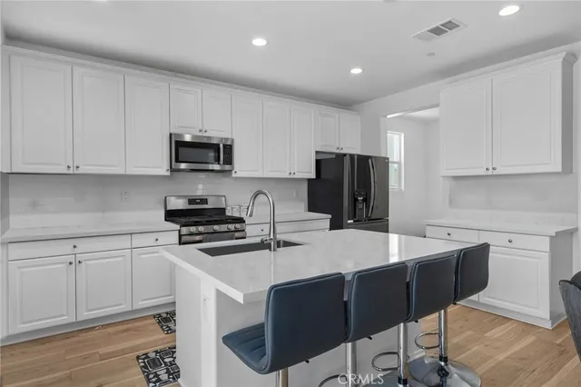 a kitchen with a sink a stove a refrigerator a microwave and cabinets