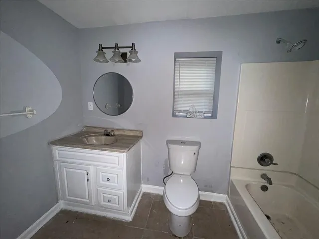 a bathroom with a granite countertop toilet sink and mirror