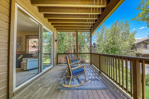 a balcony with chairs and wooden floor