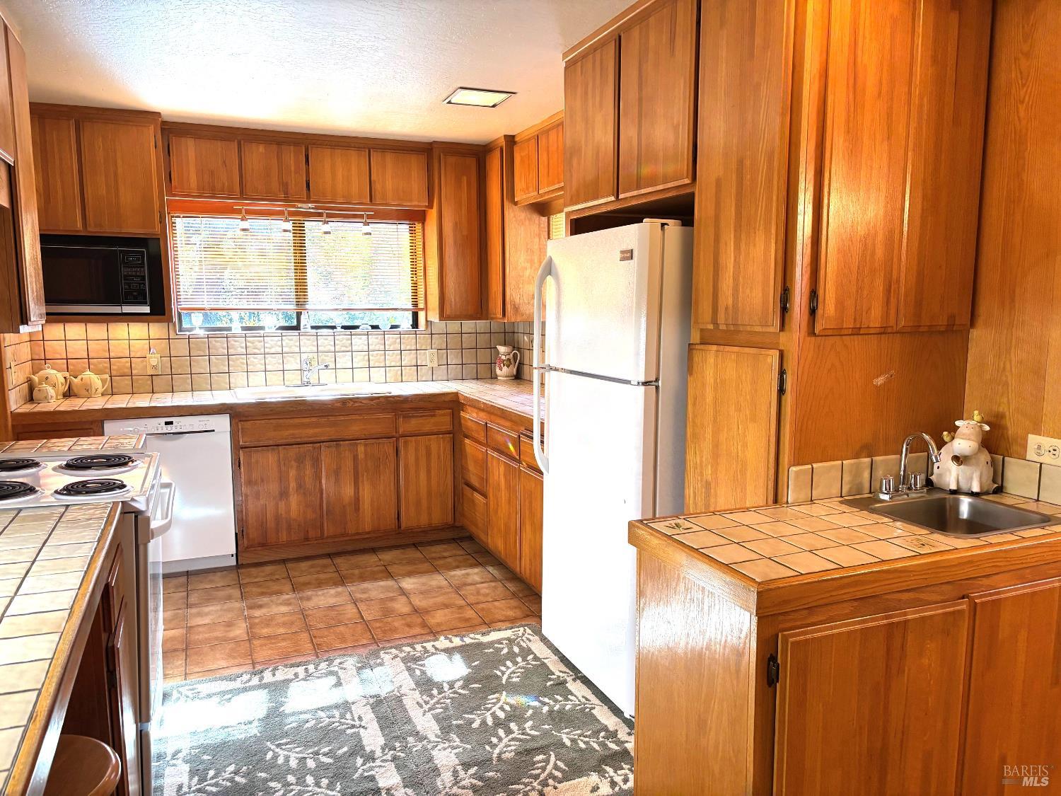 3680 Calistoga Road Santa Rosa, CA 95404 - Photo 7 of 32 a kitchen with a sink a stove and a refrigerator