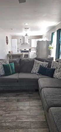 a living room with furniture and view of kitchen